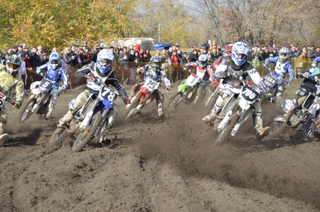 RUSSIA, SAMARA, CHAPAYEVSK - OCTOBER 17: Start, a group of motorbike racing in the MX2 class competition in the first corner the Open Cup "Volga" motocross on October 17, 2011 in Chapayevsk, Samara, Russiaのeditorial素材