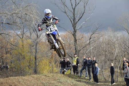 RUSSIA, SAMARA, CHAPAYEVSK - OCTOBER 17: High flight of motorcycle racer unknown on the background of clouds the Open Cup "Volga" motocross on October 17, 2011 in Chapayevsk, Samara, Russiaのeditorial素材