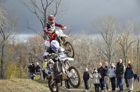 RUSSIA, SAMARA, CHAPAYEVSK - OCTOBER 17: Flying high two motorbike racing unknown  against a stormy sky the Open Cup "Volga" motocross on October 17, 2011 in Chapayevsk, Samara, Russiaのeditorial素材