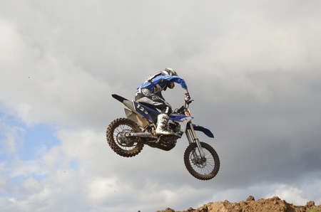 RUSSIA, SAMARA, CHAPAYEVSK - OCTOBER 17: The spectacular jump motocross racer unknown on the background a stormy sky the Open Cup "Volga" motocross on October 17, 2011 in Chapayevsk, Samara, Russiaのeditorial素材