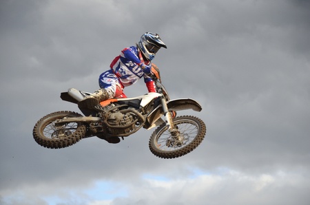 RUSSIA, SAMARA, CHAPAYEVSK - OCTOBER 17: The spectacular jump motocross racer A. Nikishkin on the background a stormy sky the Open Cup "Volga" motocross on October 17, 2011 in Chapayevsk, Samara, Russiaのeditorial素材