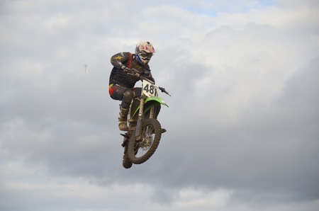 RUSSIA, SAMARA, CHAPAYEVSK - OCTOBER 17: Extreme jump racer S.Astaikin on the background of clouds the Open Cup "Volga" motocross on October 17, 2011 in Chapayevsk, Samara, Russiaのeditorial素材