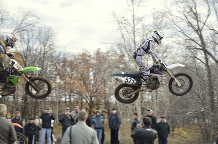 RUSSIA, SAMARA, CHAPAYEVSK - OCTOBER 17: Flying over the audience rider A.Ivanyutin on the background an autumn forest the Open Cup "Volga" motocross on October 17, 2011 in Chapayevsk, Samara, Russiaのeditorial素材