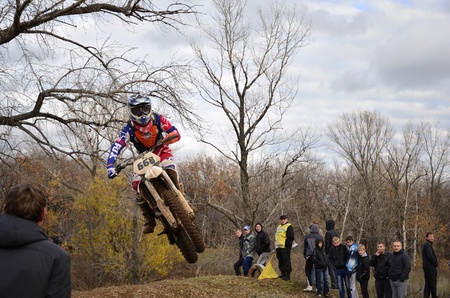 RUSSIA, SAMARA, CHAPAYEVSK - OCTOBER 17: In the air rider A.Nikishkin on the background an autumn forest the Open Cup "Volga" motocross on October 17, 2011 in Chapayevsk, Samara, Russiaのeditorial素材