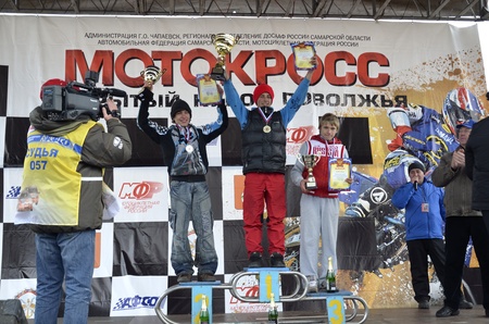 RUSSIA, SAMARA, CHAPAYEVSK - OCTOBER 17: Ceremony rewarding athletes Junior 1. I. Baranov, 2. A. Guryev, 3. N. Maslov the Open Cup "Volga" motocross on October 17, 2011 in Chapayevsk, Samara, Russiaのeditorial素材