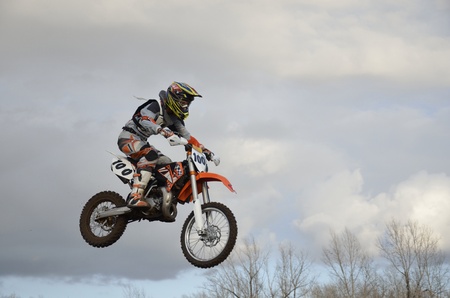 The spectacular jump motocross racer on a motorcycle on the background a stormy skyのeditorial素材