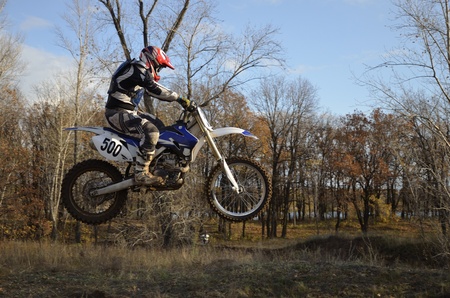 A jump rider on a motorcycle on the background an autumn forestのeditorial素材
