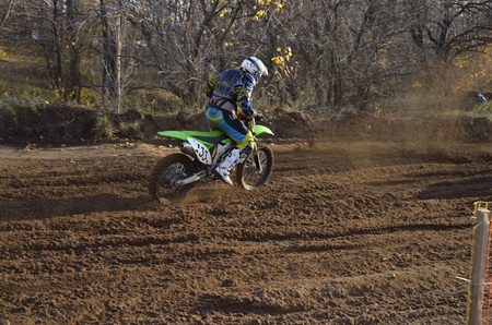 Ðotorcycle racer on a motorbike accelerating on a sandy track the motocrossのeditorial素材