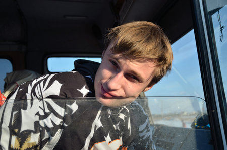 Motocross athlete is resting, his head on the open window of the cab car
