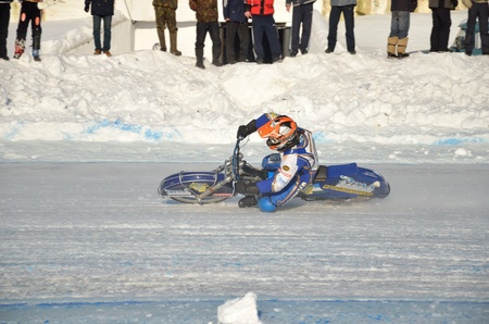 SAMARA, RUSSIA - JANUARY 27: Racing on ice, the unknown driver of a motorcycle with spikes rotates with a large slope on one knee on the ice speedway practice Championship January 27, 2012 in Samara, Russiaのeditorial素材