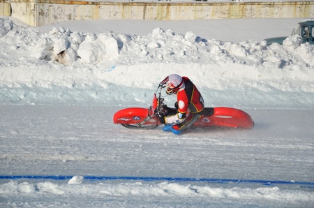 SAMARA, RUSSIA - JANUARY 29: Racing on ice, the unknown driver of a motorcycle with spikes rotates with a large slope on one knee on the ice speedway Championship January 29, 2012 in Samara, Russiaのeditorial素材
