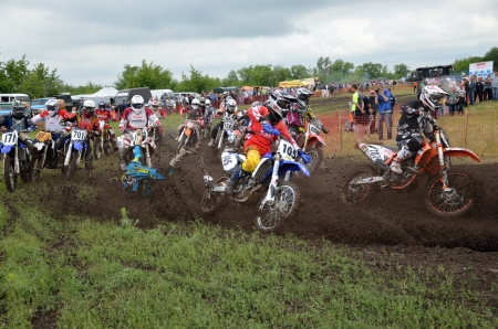 RUSSIA, SAMARA - JUNE 16: Group of riders the start,  hole shot parts, rider turning falls the Open class the Regional Motocross Championship on June 16, 2012 in Samara, Russiaのeditorial素材