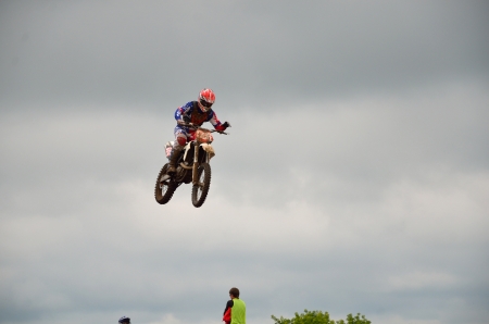 RUSSIA, SAMARA - JUNE 11: The spectacular jump motocross racer A. Nikishkin on the background a stormy sky the Open class the Regional Motocross Championship on June 11, 2012 in Samara, Russiaのeditorial素材