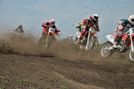 RUSSIA, SAMARA - JUNE 16: Group of riders the start  holeshot parts in the first corner the Cup of Russia in motocross, the class of "veterans" on June 16, 2012 in Samara, Russiaのeditorial素材