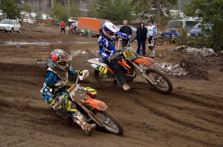 Two riders MX 100 E. Rekshin, 31 N. Misyulya compete in turning, on a sandy track ruts, the Motocross practice April 8, 2012 in Samara, Russiaのeditorial素材