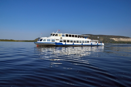 River transport for walks and rest in the middle of the river, against the mountainsの写真素材