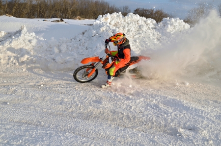 Motocross winter turn with emphasis in a snowdrift racer and motorcycleの写真素材