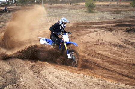 Motorcycle rider bogged down in loose sand on a steep bend motocross trackの写真素材