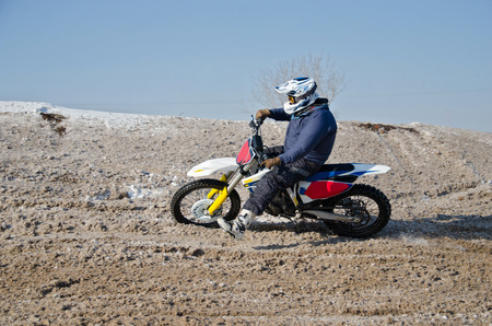 MX rider on a snowy hill with a slope turns motorcycleの写真素材