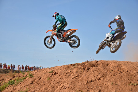 RUSSIA, SAMARA - SEPTEMBER 26: Two participants of motocross, 98 Bikteev I. 515 Nesytyh W., fly across the hill, the Regional Motocross on September 26, 2015 in Samara, Russiaのeditorial素材