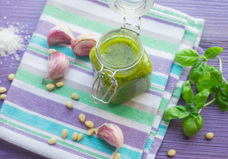 Green pesto in a glass jar and ingredientsの写真素材