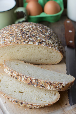 Freshly baked homemade bread with oatmeal, poppy seeds and flax seedの写真素材