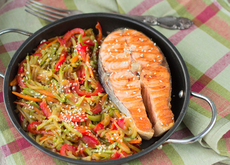 Salmon steak with vegetables in pan portionの写真素材