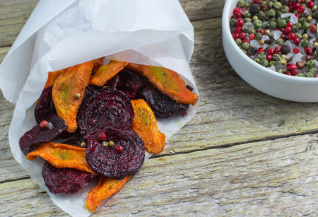 Carrots and beets . Healthy organic vegetable chips with coarse sea salt, pepper and coriander. Selective focusの写真素材