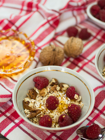 Healthy Breakfast. Homemade granola with raspberries, walnuts and honey. Shallow depth of fieldの写真素材
