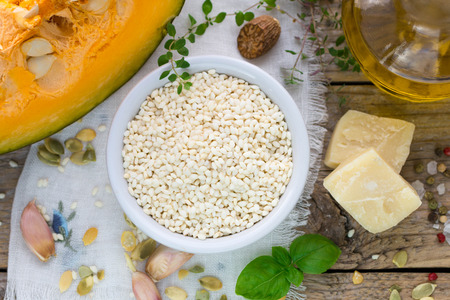 Raw rice and cooking ingredients for risotto with pumpkin. Selective focusの写真素材