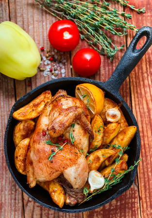 Baked chicken with potatoes, garlic, lemon and thyme. A delicious dinner in the rustic style. Selective focus. Top viewの写真素材