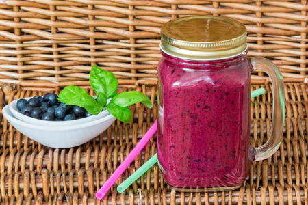 Healthy Breakfast. Blueberry smoothie in a mason jar and fresh juicy blueberries on a wicker table. Selective focusの写真素材