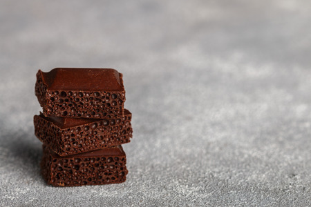 Porous milk chocolate, broken into pieces. Selective focusの写真素材