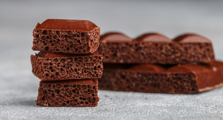 Porous milk chocolate, broken into pieces. Selective focusの写真素材