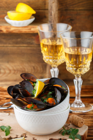 Mussels in wine with parsley and lemon. Seafood. Clams in the shells. Delicious snack for gourmands. Selective focusの写真素材