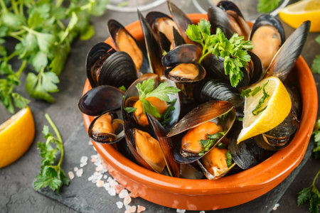 Mussels in wine with parsley and lemon. Seafood. Clams in the shells. Delicious snack for gourmands. Selective focus
