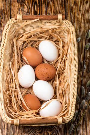 White and brown eggs in the basket on the table. Easterの写真素材