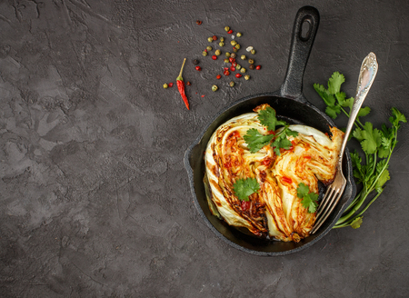 Baked organic cabbage with spices, cilantro and hot sauce. Selective focus. Copy space. Top viewの写真素材