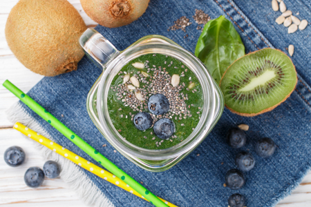 Healthy green smoothie and the ingredients - spinach, banana, kiwi, Chia seeds, sunflower seeds and blueberries. Detox. Healthy Breakfast. Selective focusの写真素材