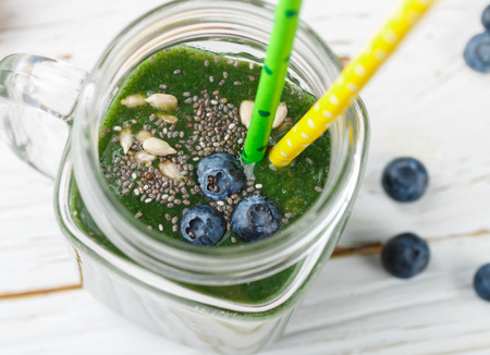 Healthy green smoothie and the ingredients - spinach, banana, kiwi, Chia seeds, sunflower seeds and blueberries. Detox. Healthy Breakfast. Selective focusの写真素材