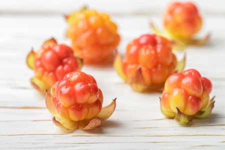 Fresh organic Berry cloudberries on light wooden background. Selective focusの写真素材