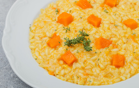 Risotto with pumpkin and thyme in a white plate. Selective focusの写真素材