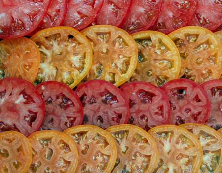Slices of red and yellow tomatoes. Culinary background. Selective focusの写真素材