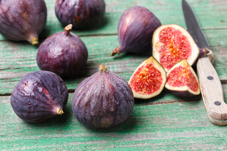 Fresh ripe organic figs with drops of water on a wooden table. Selective focusの写真素材