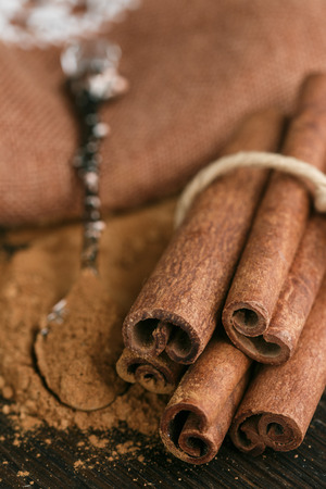 Cinnamon sticks and powder on rustic wooden Board closeup. Spices. Seasonings. Selective focusの写真素材