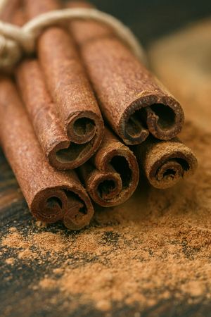 Cinnamon sticks and powder on rustic wooden Board closeup. Spices. Seasonings. Selective focusの写真素材