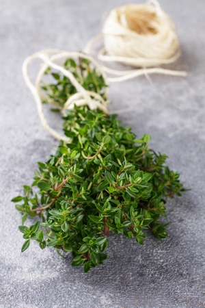 Sprigs of fresh organic thyme on a stone or concrete table. Herbs. Selective focusの写真素材