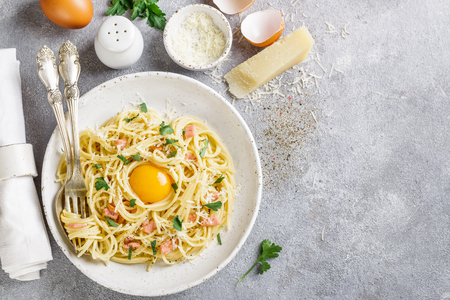 Pasta Carbonara. Spaghetti with bacon, egg, parsley and Parmesan cheese closeup. A traditional Italian dish. Selective focus. The top view and copy spaceの写真素材