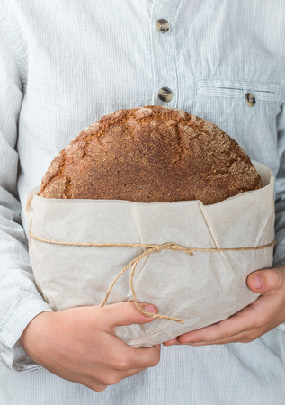 loaf of fresh rye bread in children's hands. Selective focusの写真素材