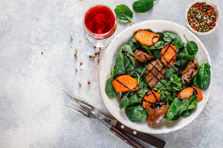 Warm spinach salad with chicken liver and baked pumpkin with spices and balsamic.の写真素材